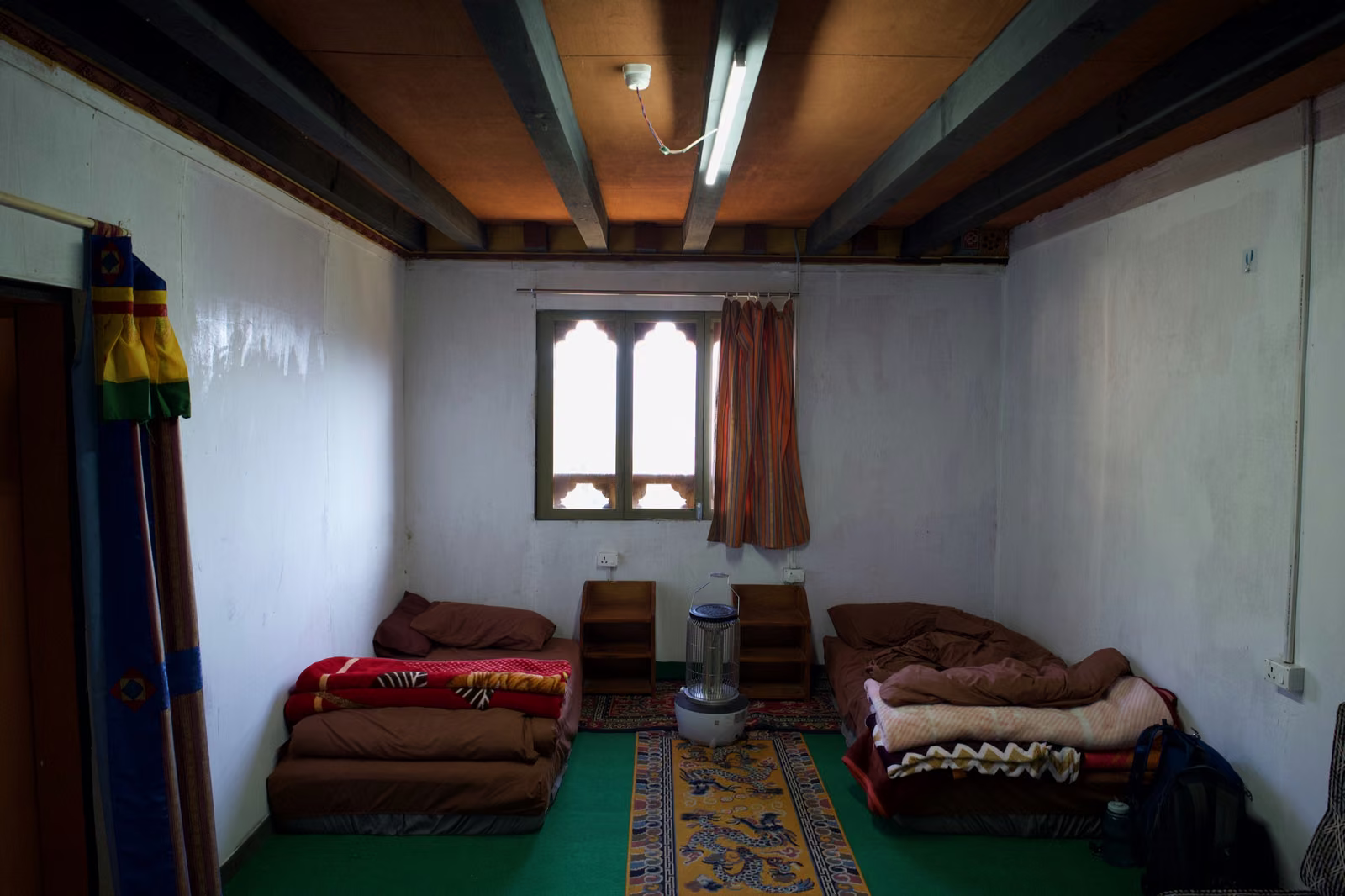 A simple room at Dodeydra with low beds, blankets and a small window.