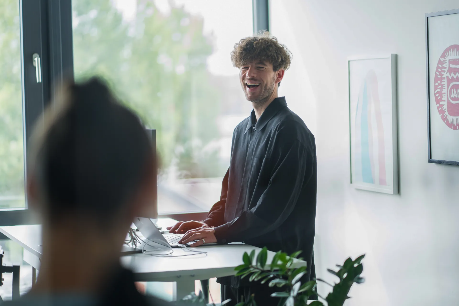 Unterhaltung zwischen zwei Mitarbeitenden am Schreibtisch