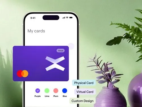 A smartphone screen displays a digital wallet app titled “My cards,” showing a virtual card with a purple design and Mastercard logo. Below it are color options for customization (Purple, Lime, Plum, Blue), and tags for selecting Physical Card, Virtual Card, or Custom Design. Decorative plants are placed beside the phone on a pastel green background.