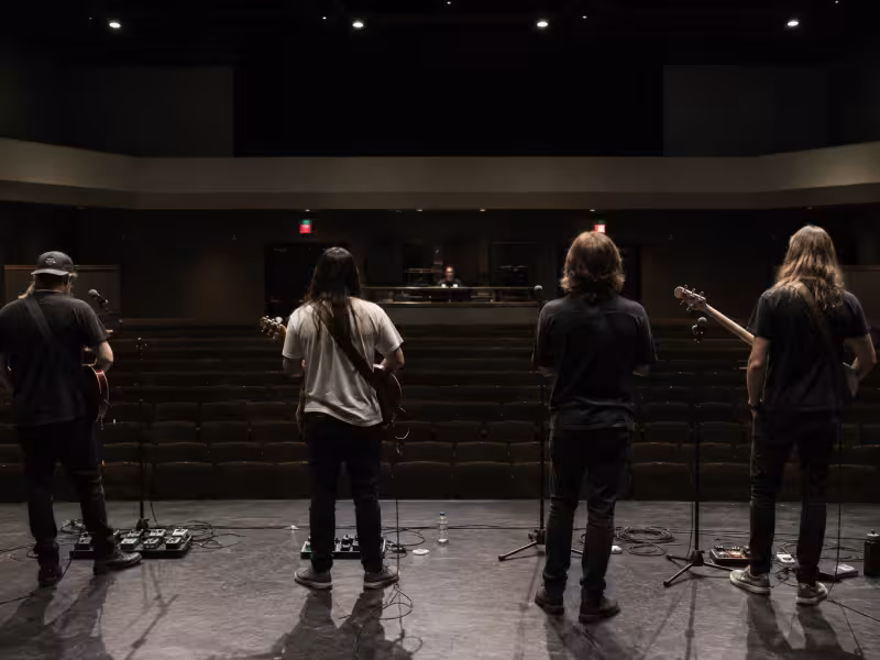4 piece band on stage performing sound check