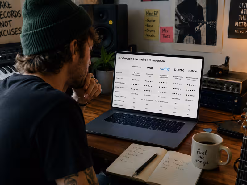 Indie musician comparing Bandzoogle alternatives on a laptop in a home studio