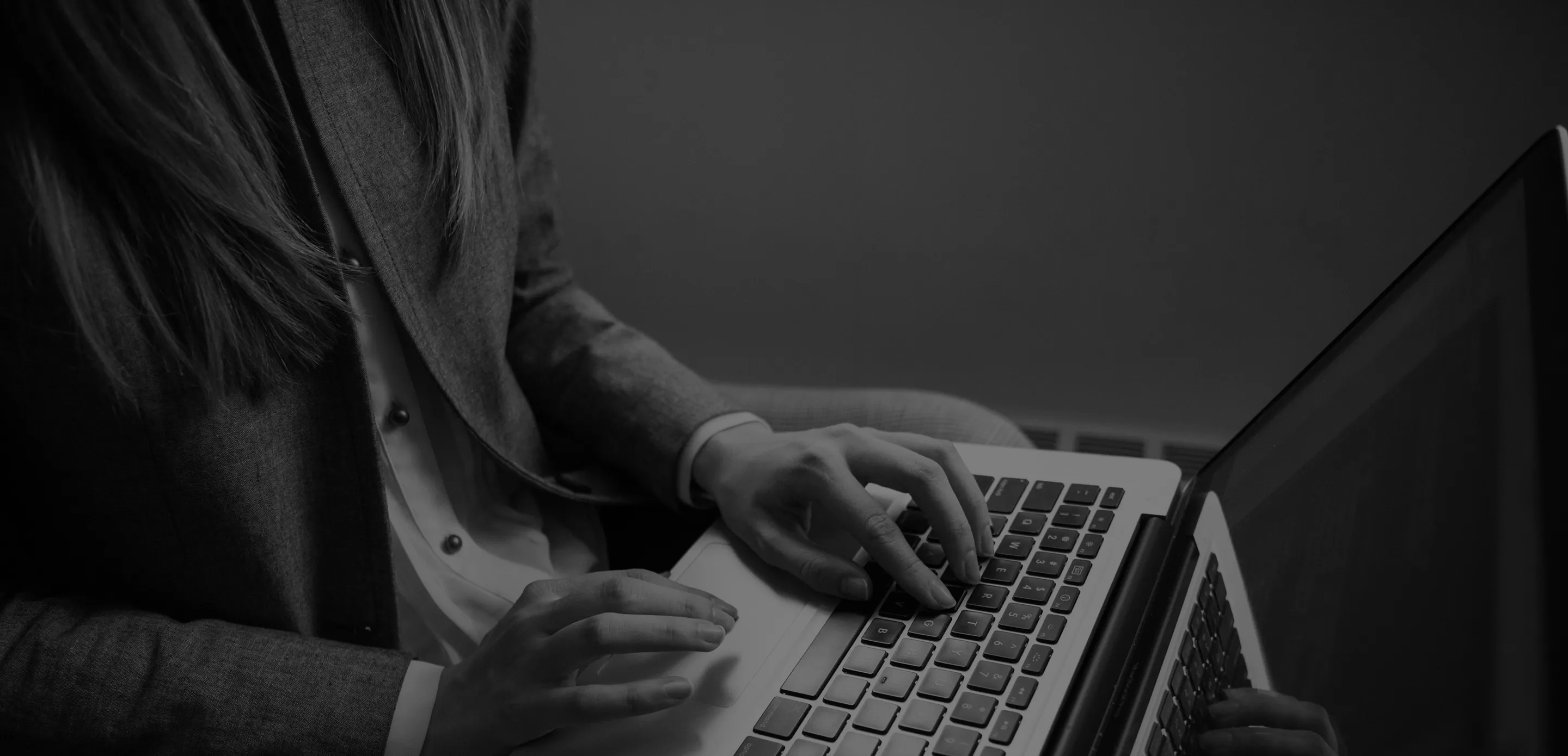 A woman is typing on a laptop computer.