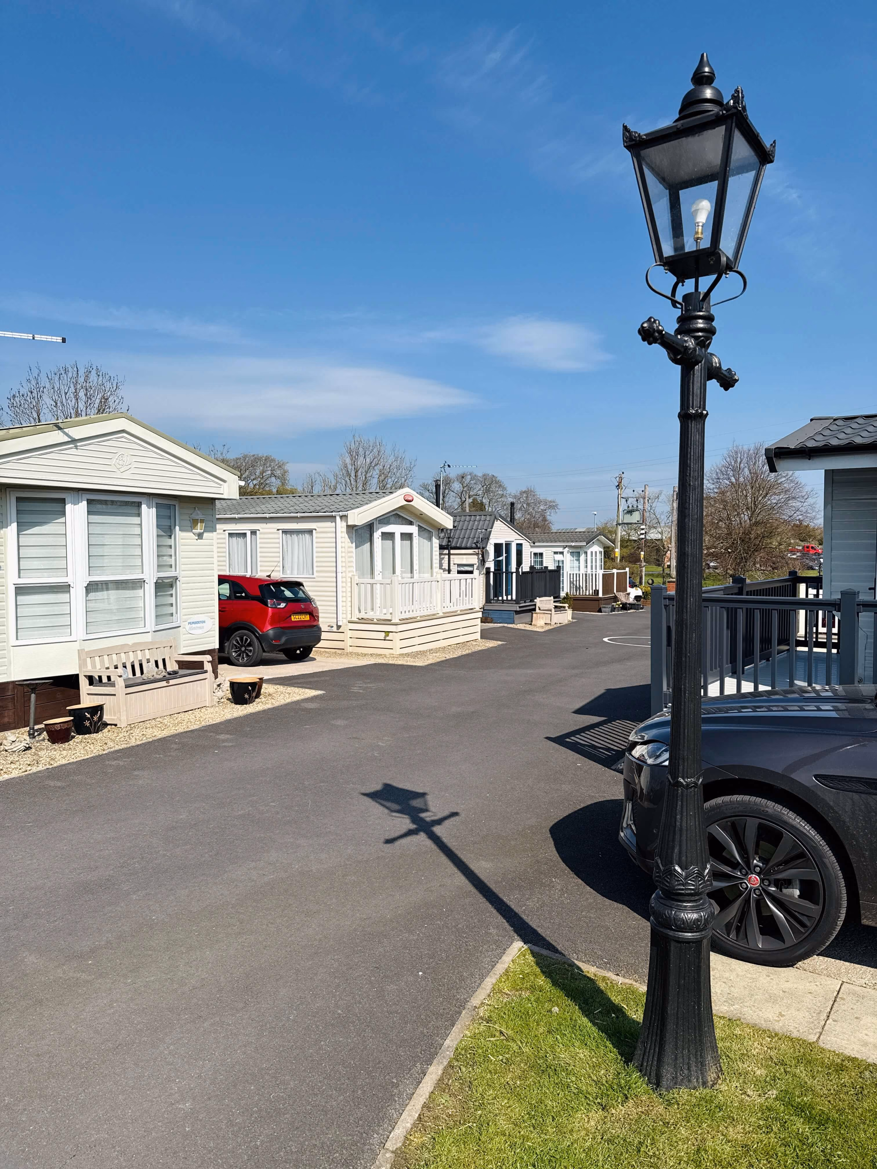 Mobile homes with ornate lamp post on sunny day in residential park