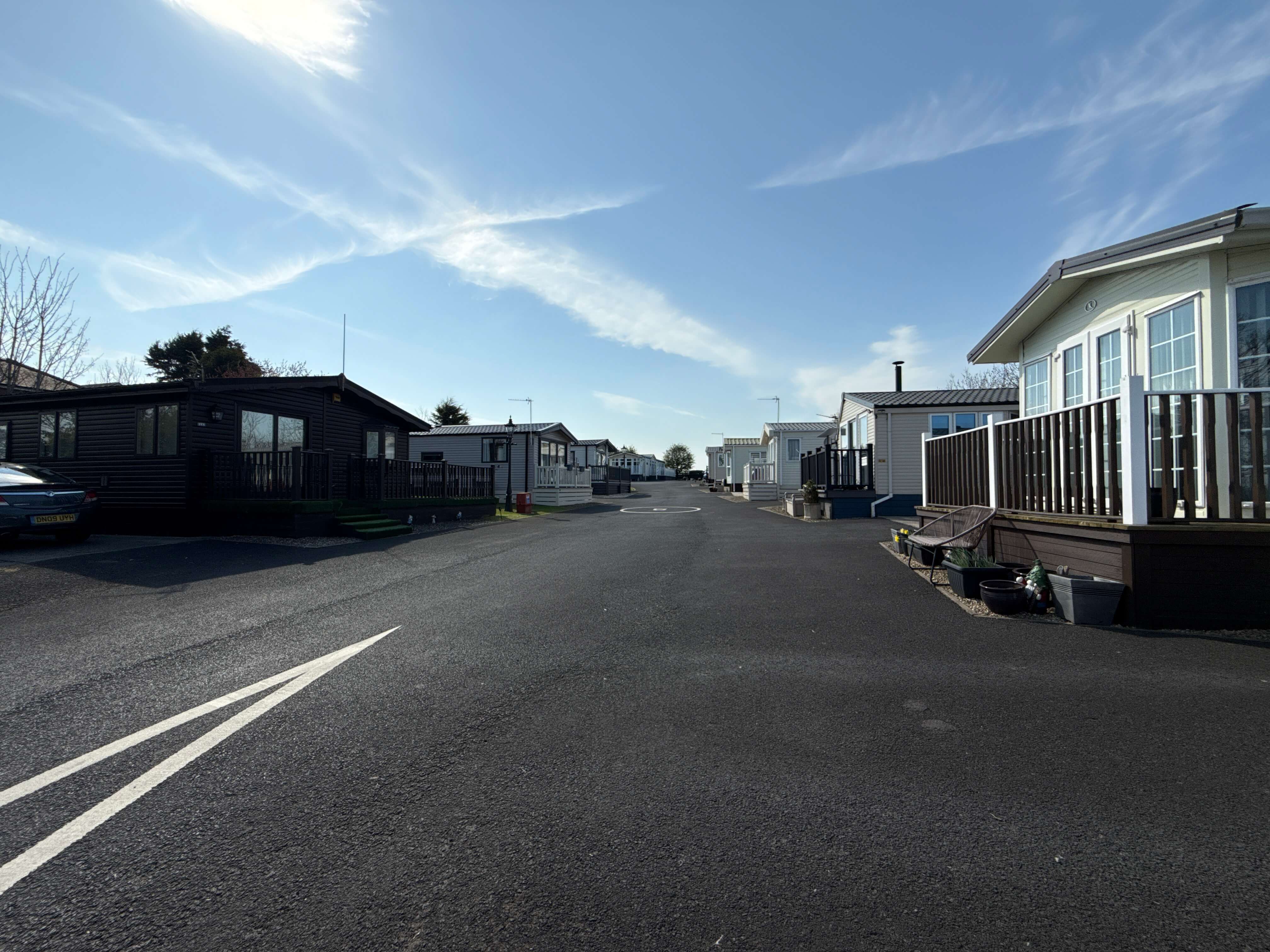 Empty road through mobile home park with clear blue sky