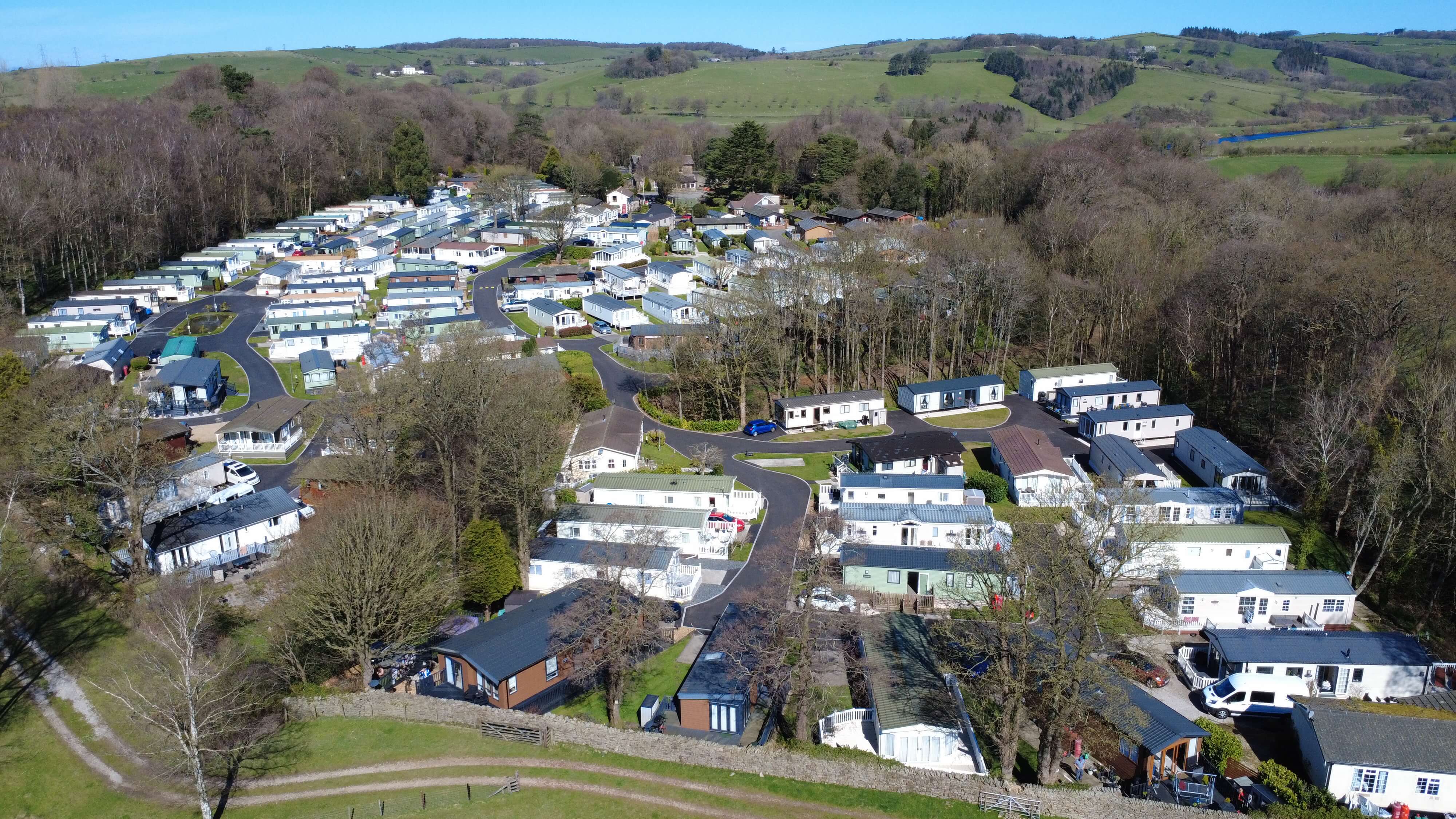 Aerial view of a mobile home park nestled in green rolling countryside