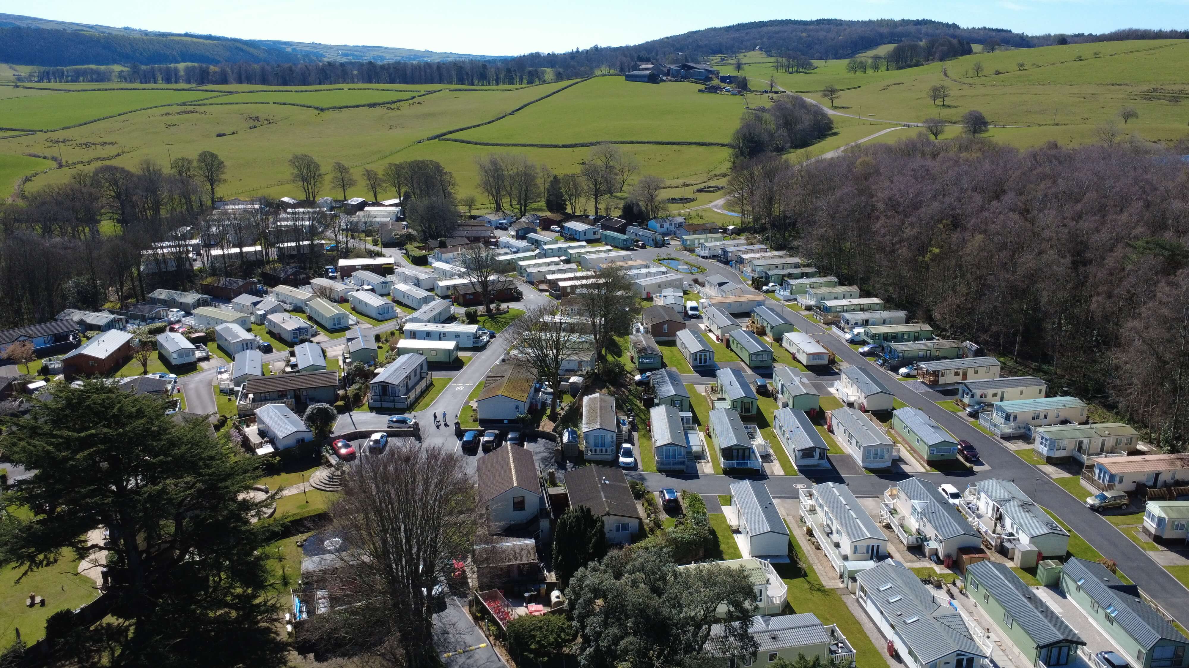 Aerial view of mobile home park nestled in green countryside with trees