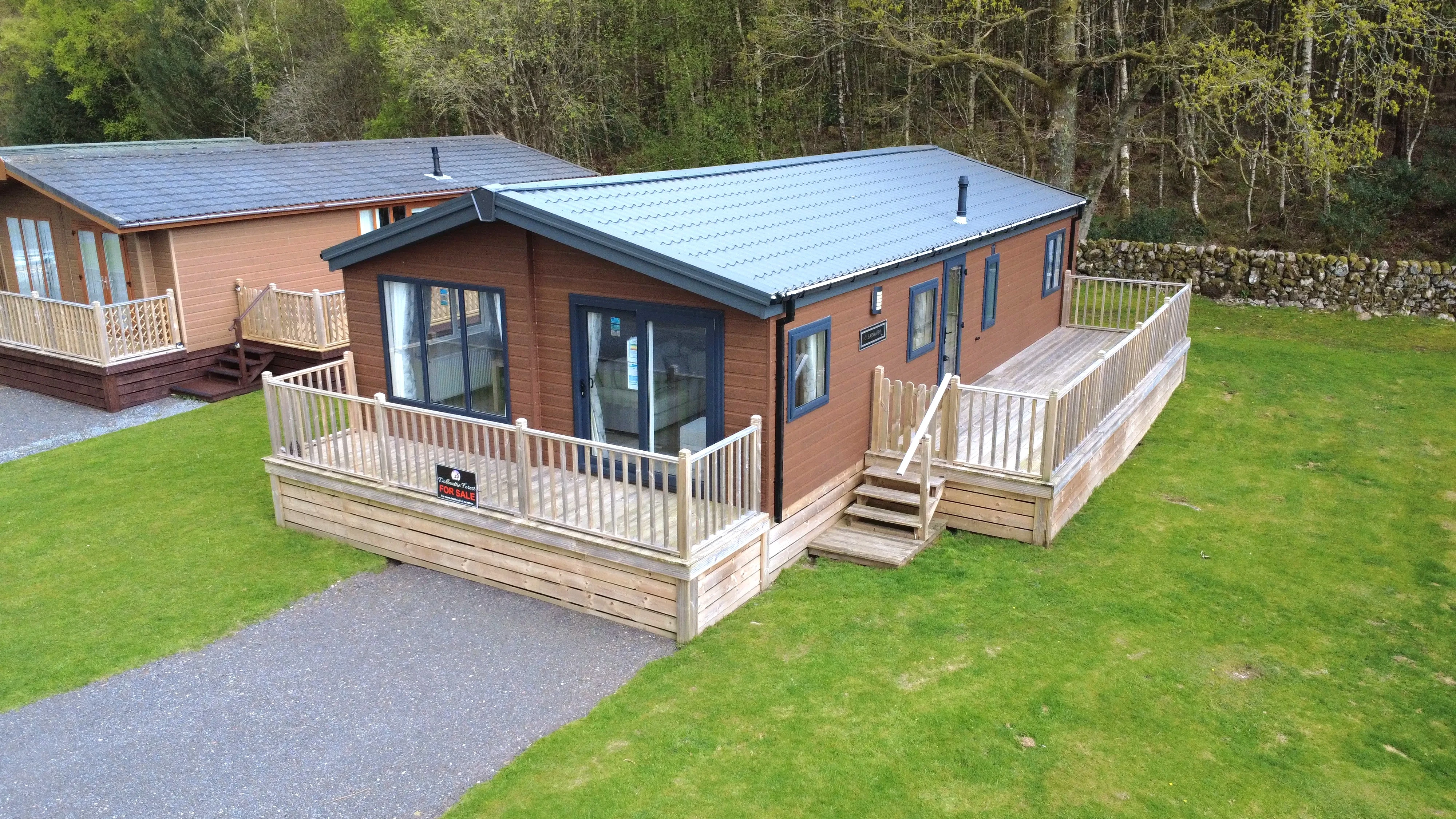 Wooden vacation lodge with large deck in forested campground setting