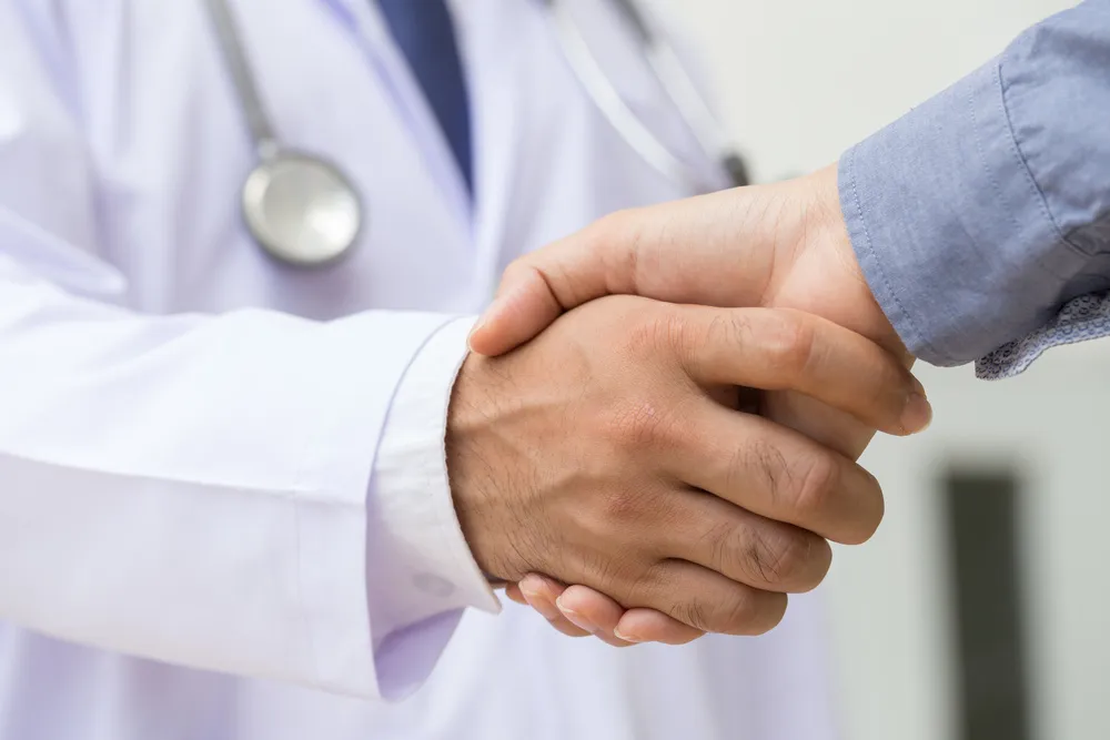 A close up of two people shaking hands.