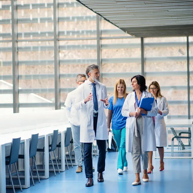 A group of people walking down a hallway.