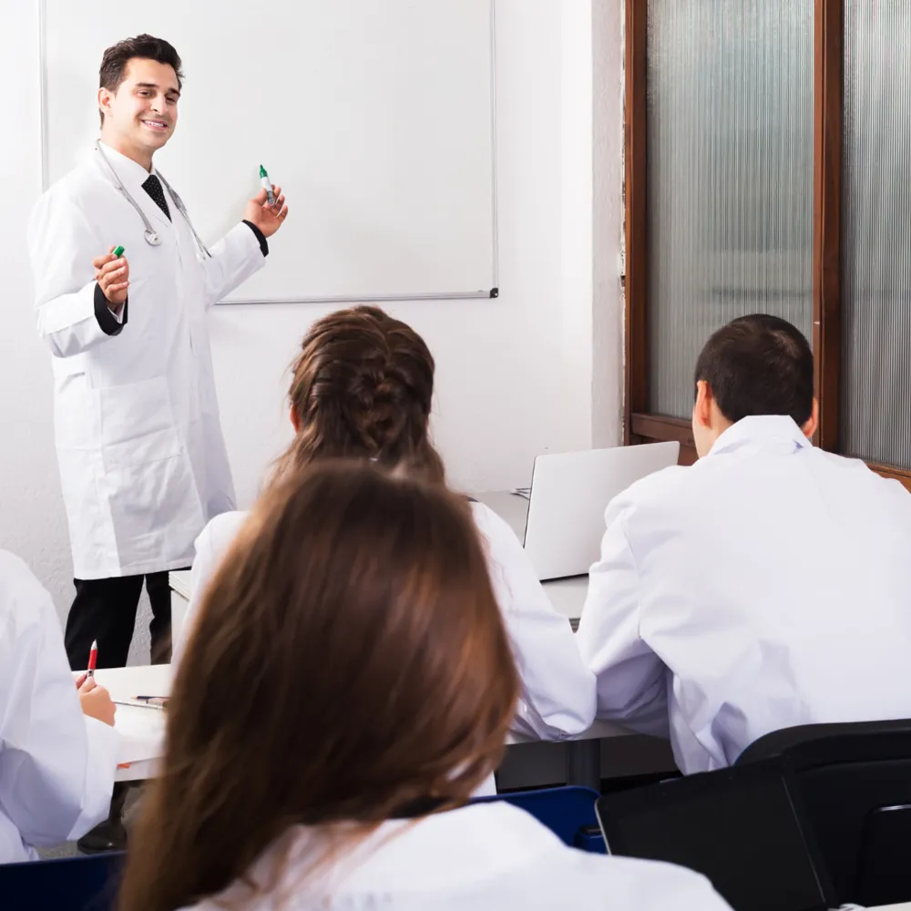 A man in a lab coat giving a presentation to a group of people.
