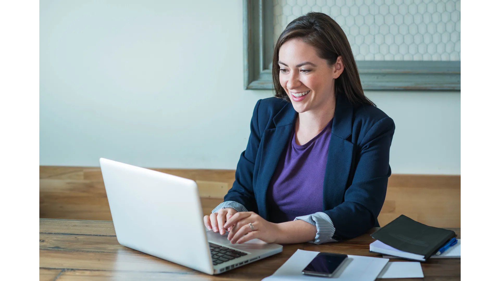 A woman sitting at a table with a laptop.