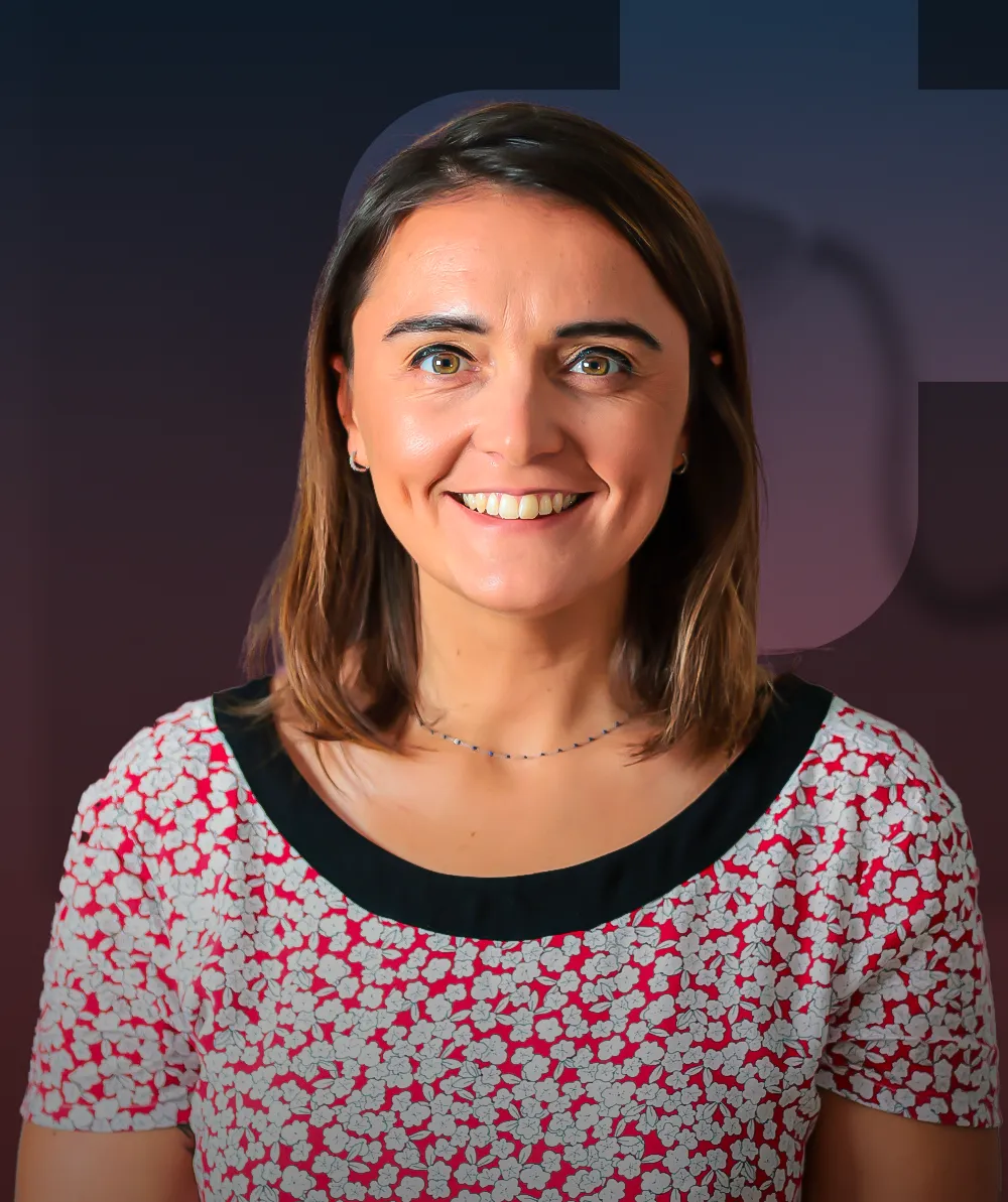 A woman in a red and white shirt smiles at the camera.