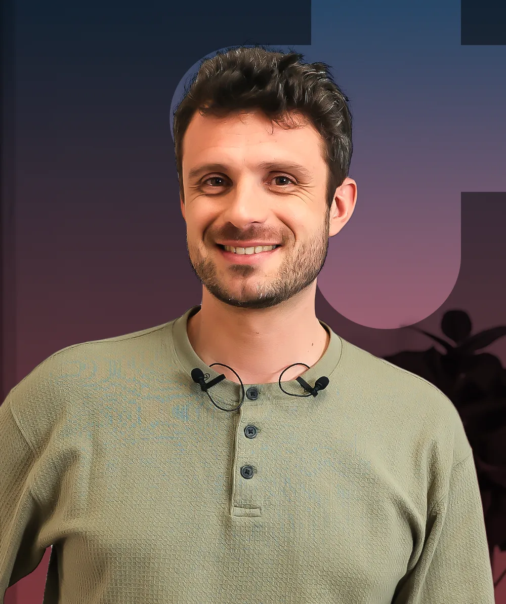 A man in a green shirt smiling at the camera.
