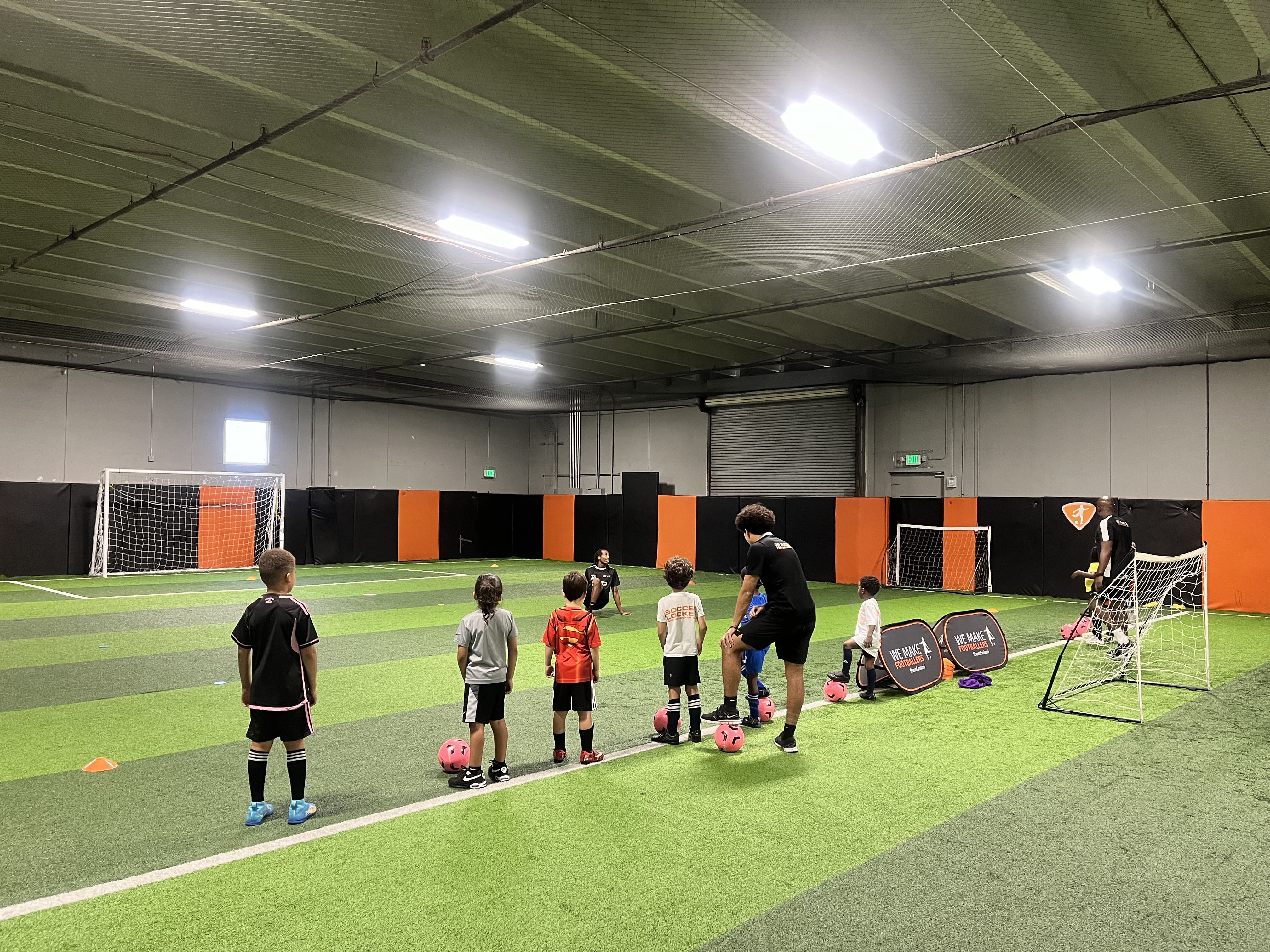 Diverse group of kids playing football together during a fun, inclusive session.