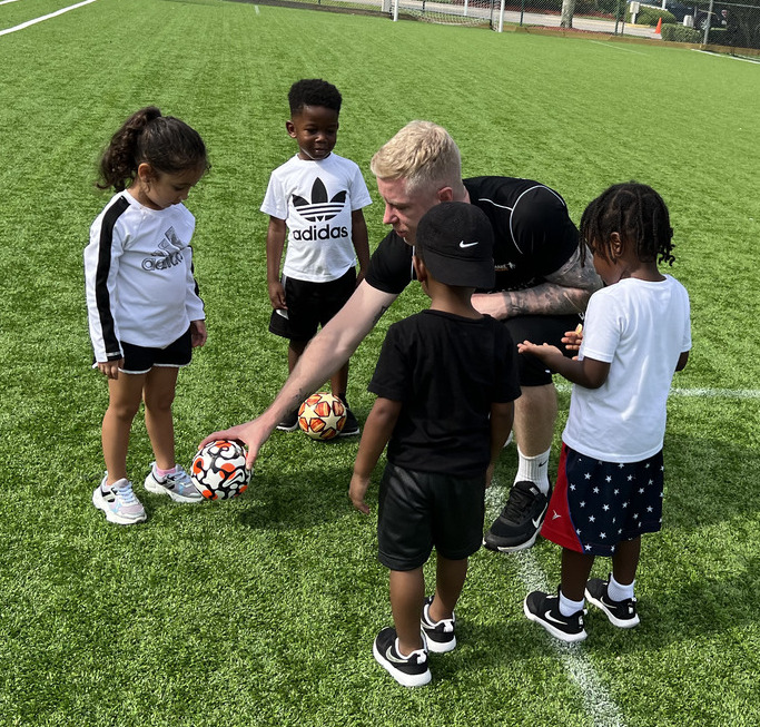 Child practicing soccer skills with focus and determination.