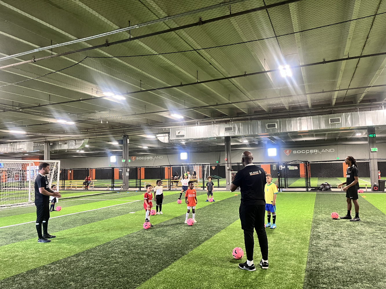 Soccer coach leading a small group training session with young kids aged 4–8