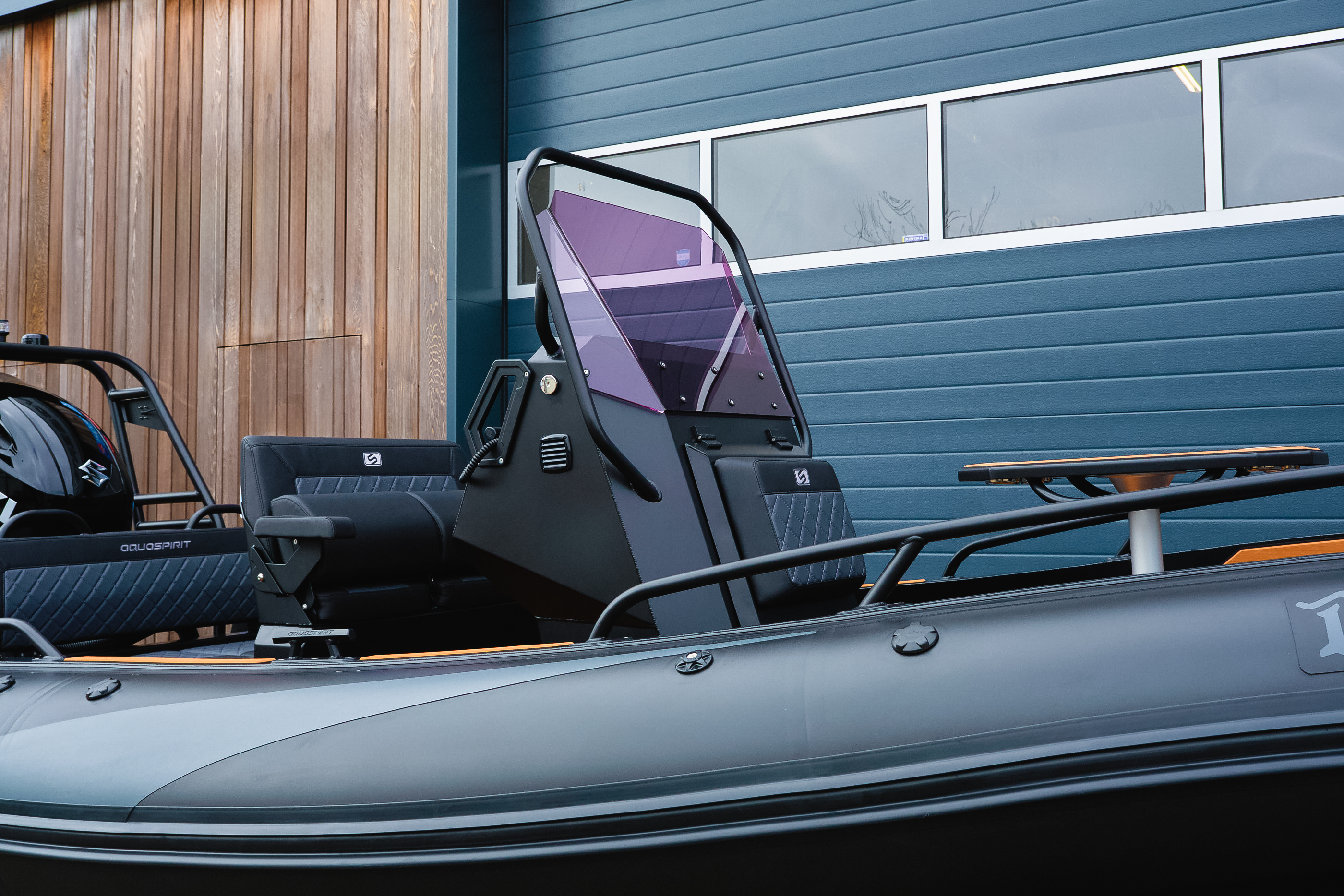 Aquaspirit RIB with black inflatable tubes planing on open water