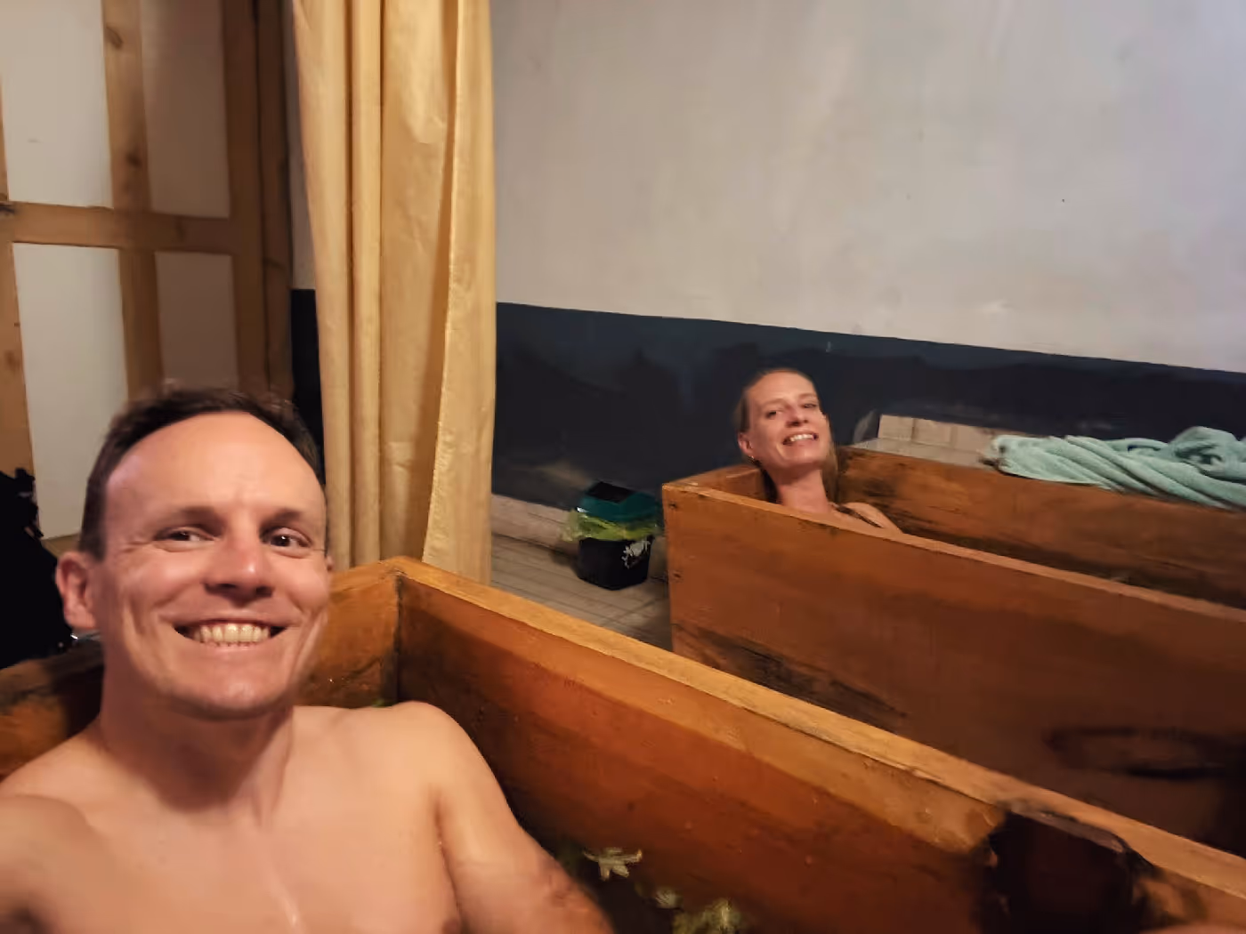 International guests enjoying a traditional Bhutanese hot stone bath in wooden tubs.