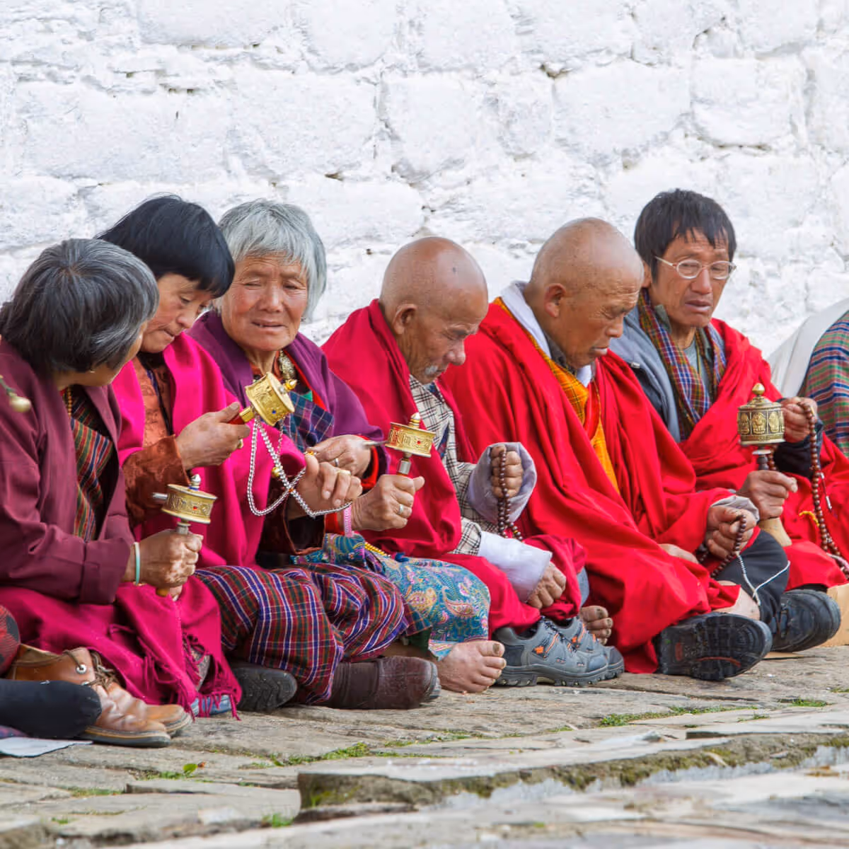 Elderly Bhutanese pilgrims turning prayer wheels in Thimphu