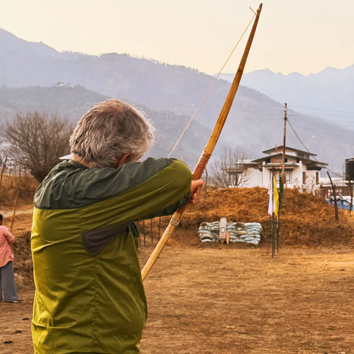 Guest practicing archery in a Bhutanese village field