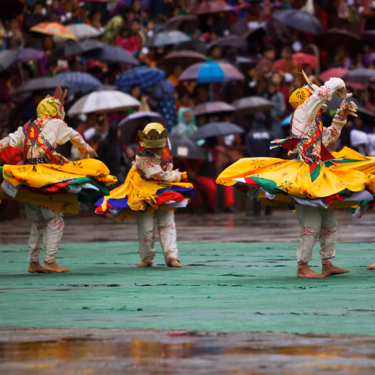 Masked dancers in vibrant costumes performing at Bhutanese festival.