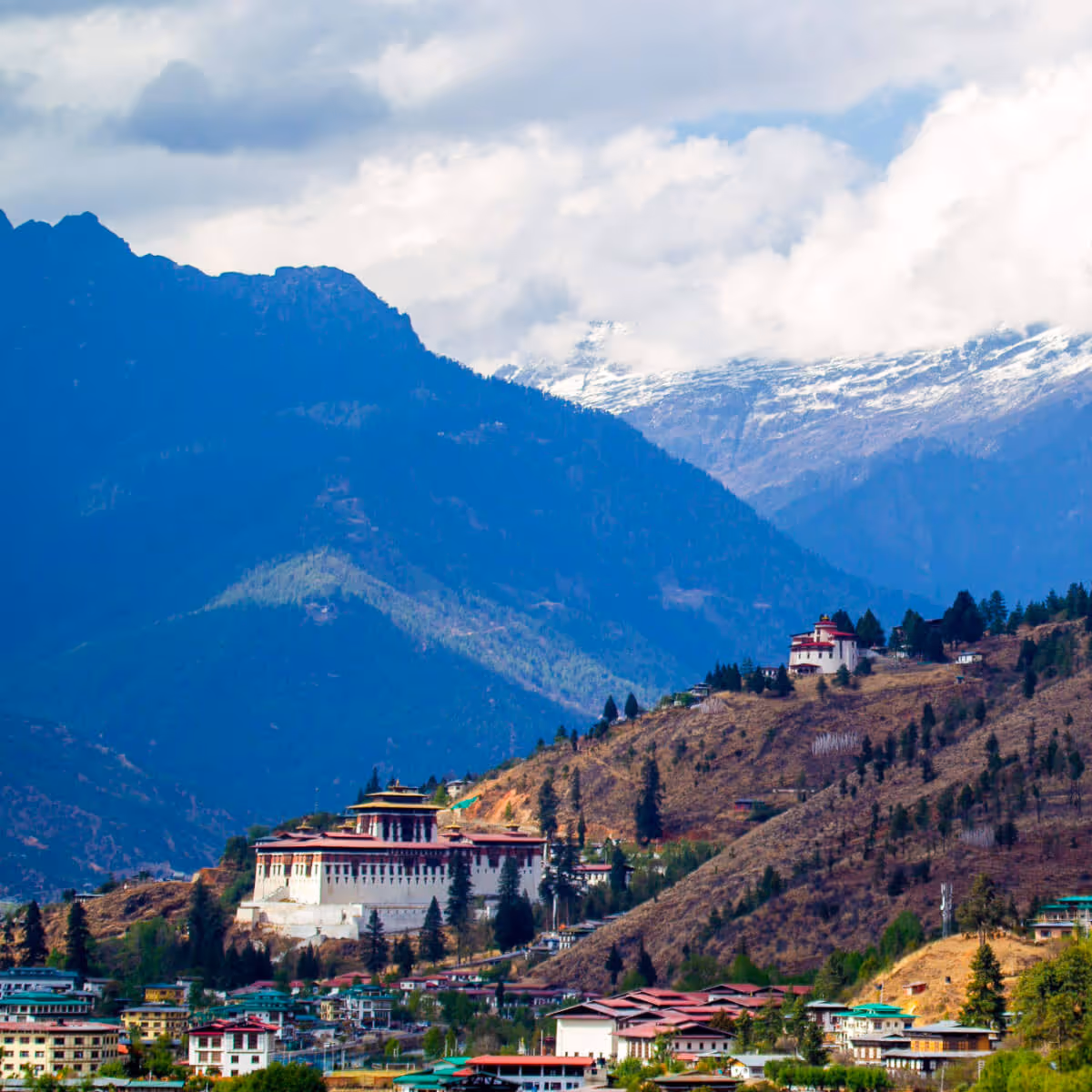 Paro Dzong overlooking Paro valley with snow-capped mountains in Bhutan.