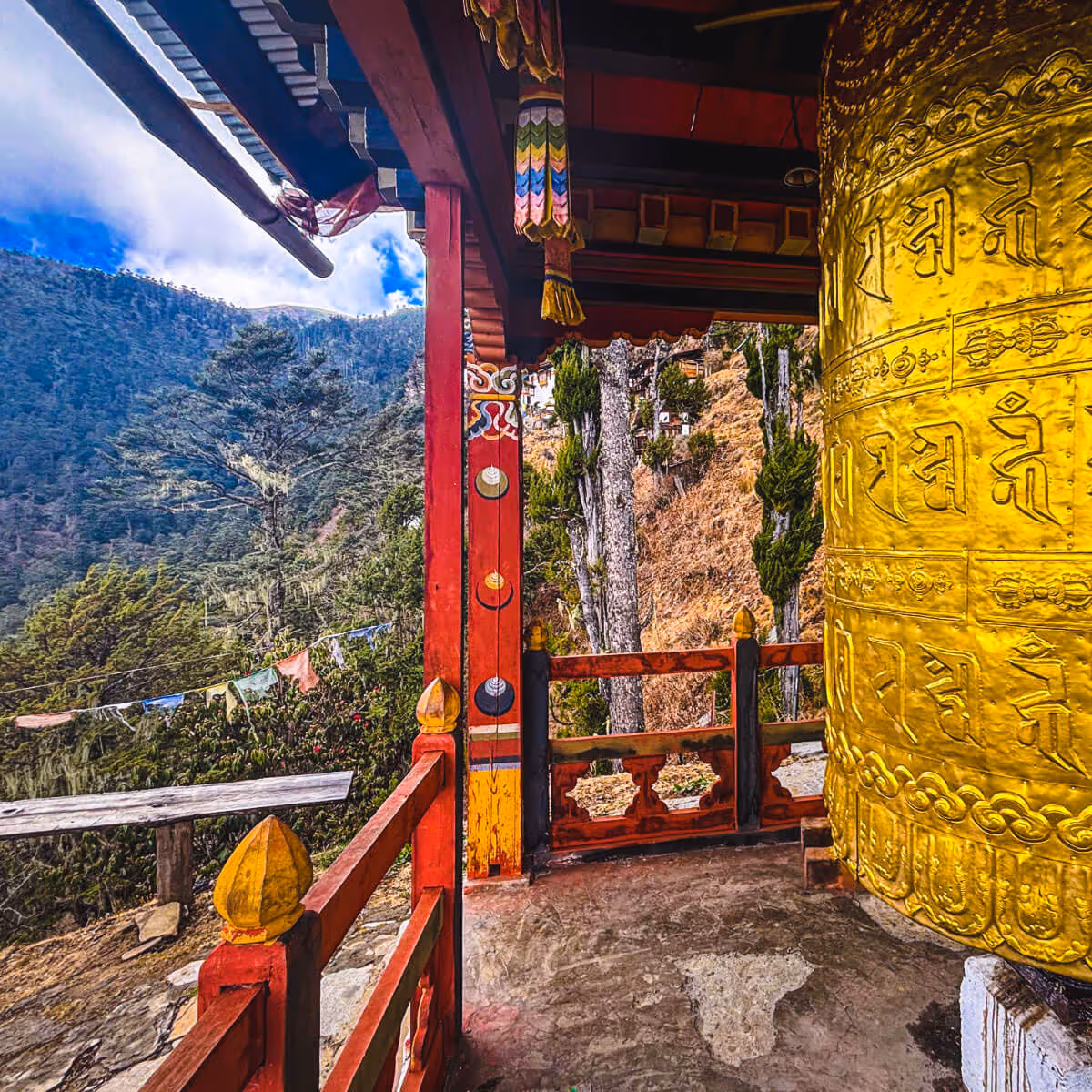 Golden prayer wheel at Kila Nunnery Bhutan with forest backdrop
