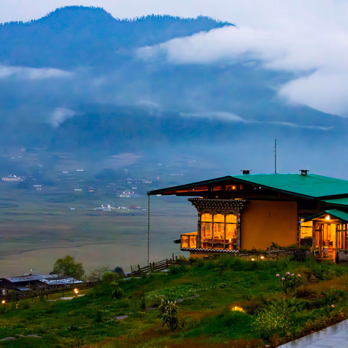 Gangtey Tent Resort glowing at dusk, overlooking Phobjikha Valley in Bhutan.