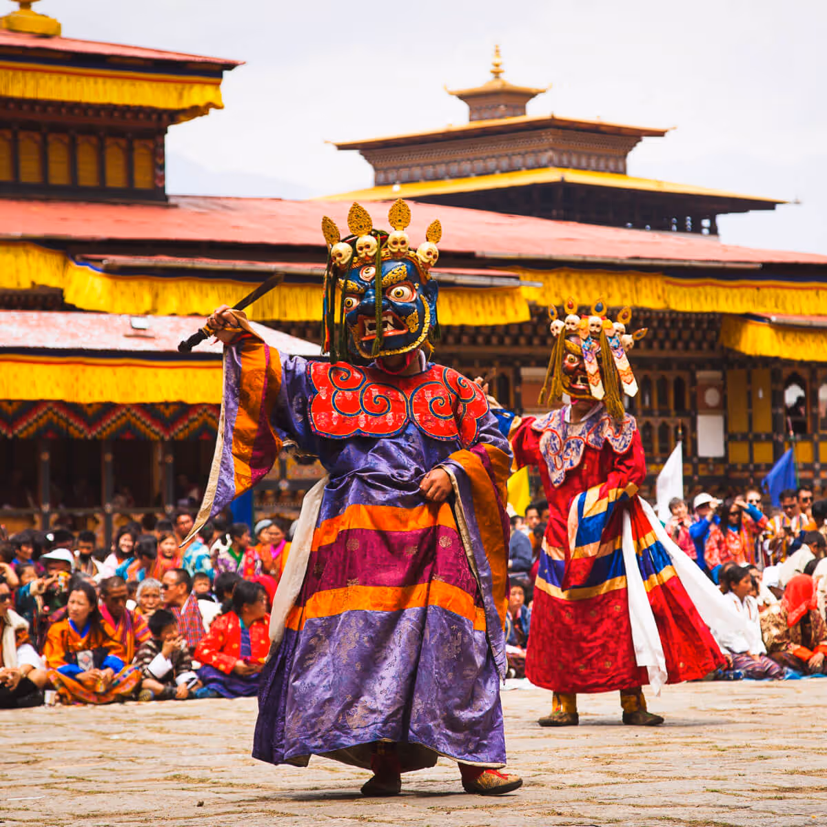 Masked dancers performing cham at a monastery festival in Bhutan.