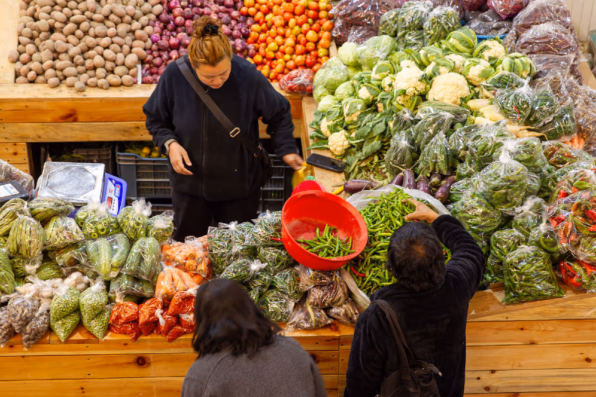 Shoppers choosing fresh vegetables at a local Bhutanese market stall.
