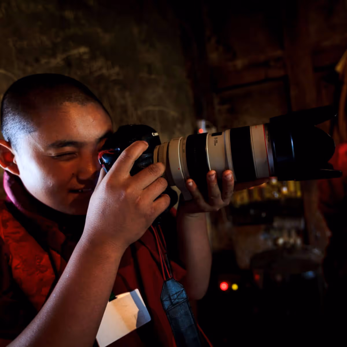 Bhutanese monk photographing with a long lens camera