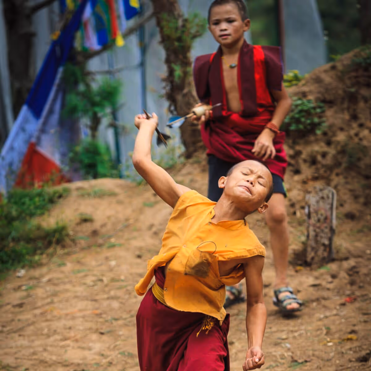 Young Bhutanese monk playing traditional dart game