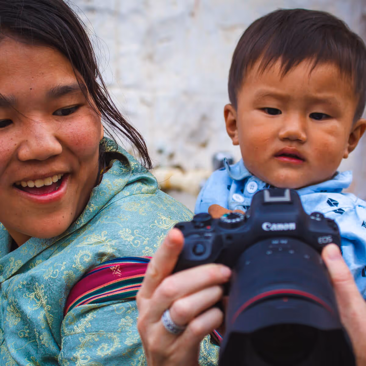 Bhutanese woman and child exploring a camera together