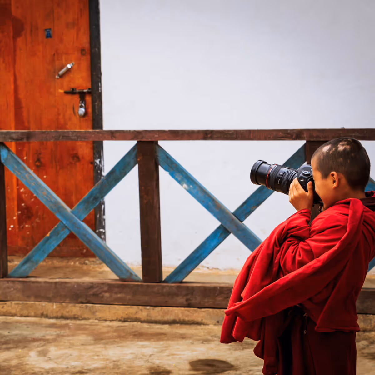 Monk child taking photos with professional camera in Bhutan