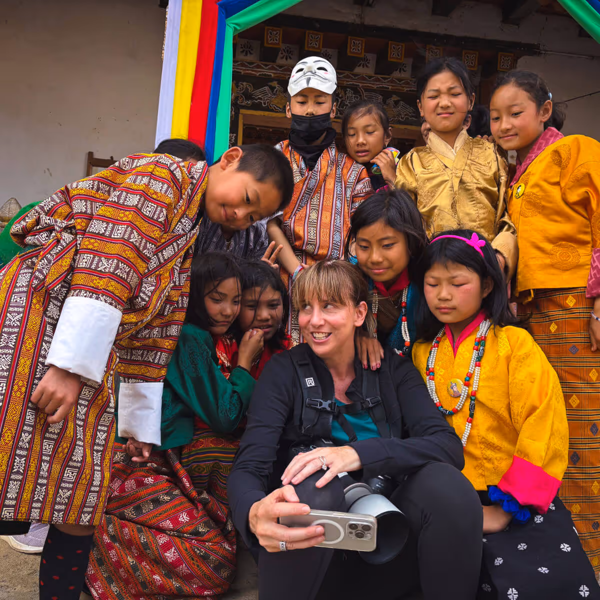 Photographer showing group of Bhutanese children their photos.