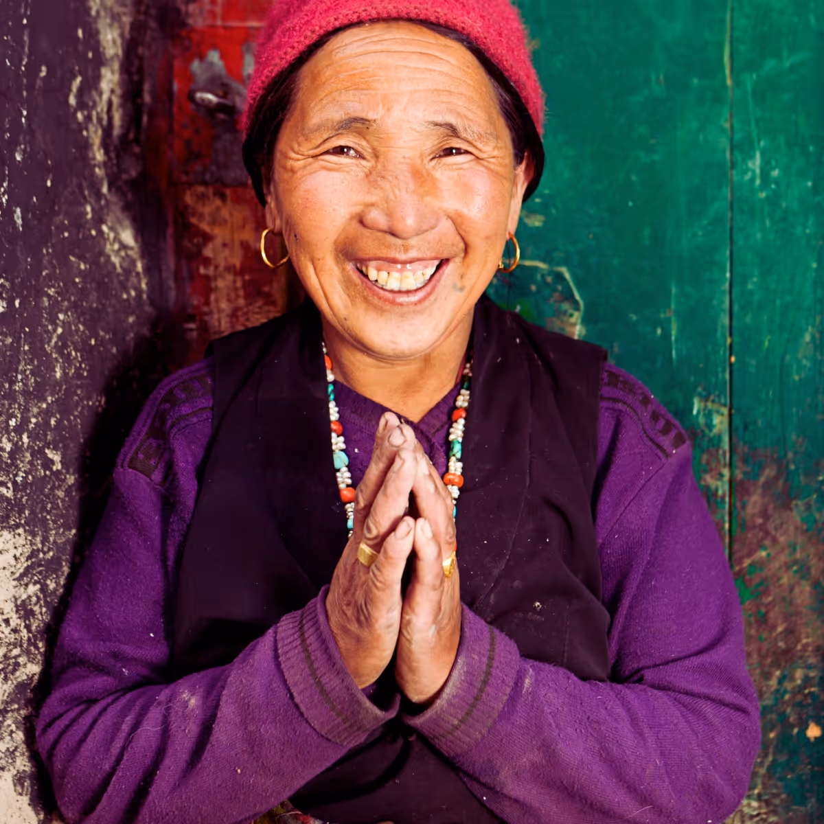 Smiling woman greeting with namaste in Mustang, Nepal
