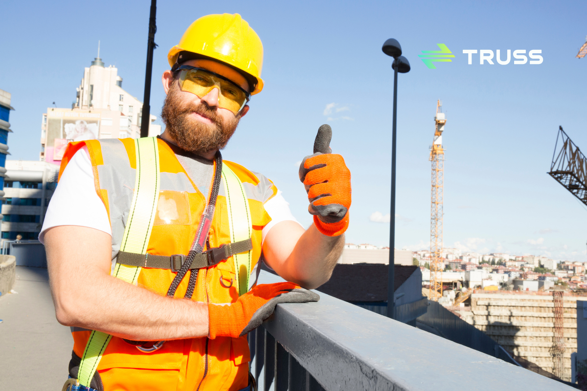 Construction worker in hard hat and safety vest giving a thumbs up on a job site, symbolizing confidence in construction finance solutions
