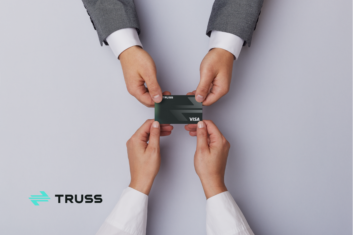 Two people exchanging a Truss Visa card – construction payment platform