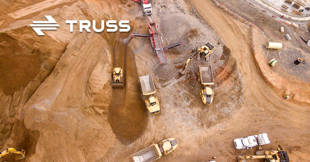 Aerial view of a construction site with heavy machinery and trucks, representing how SAʴý job construction software helps contractors track projects efficiently.