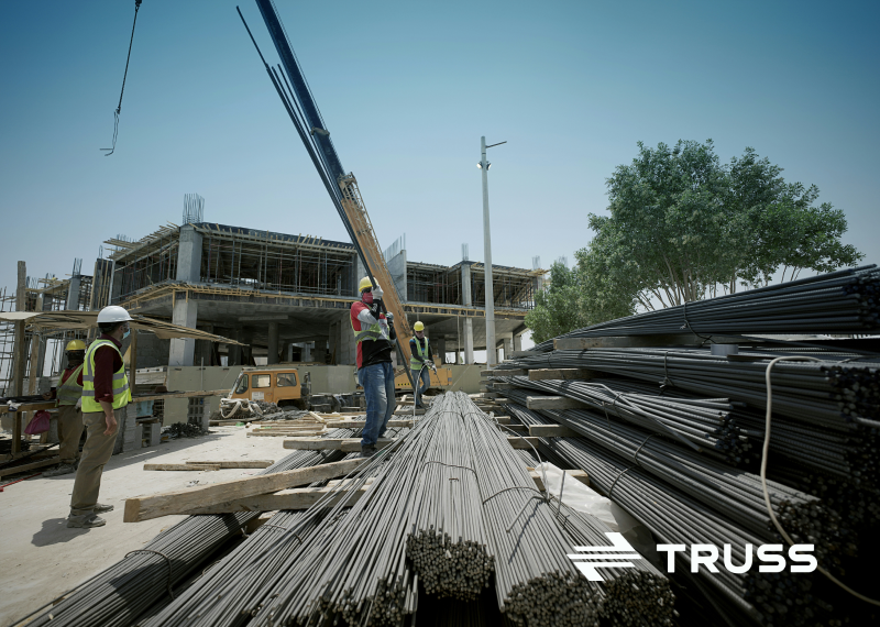 Construction workers managing rebar on a building site, representing how SAʴý job cost accounting software helps contractors track expenses and stay on budget.