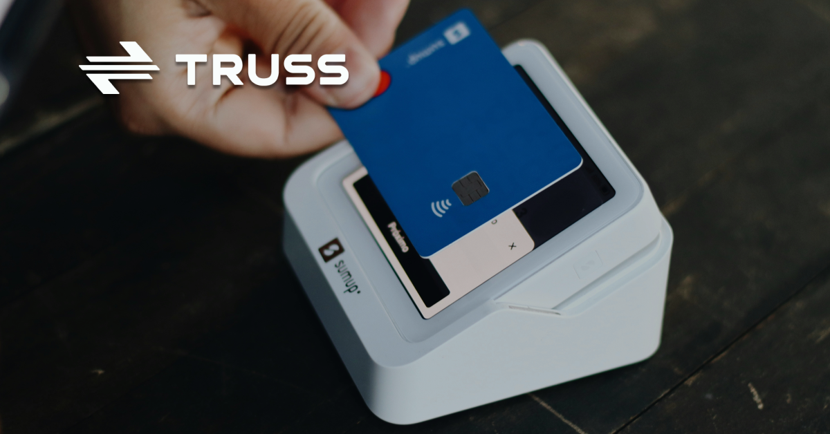 Person tapping a blue credit card on a payment terminal, representing how SAʴý simplifies construction payments using virtual cards and ACH transfers.