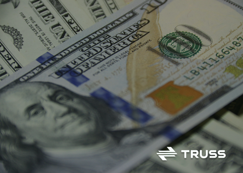 Close-up of U.S. hundred-dollar bills representing contractor cash flow management and financial stability in construction projects.