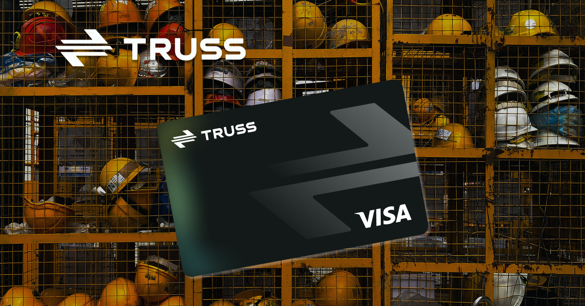 A black Truss Visa business card displayed in front of a construction site locker filled with safety helmets, symbolizing modern financial tools designed for construction businesses.