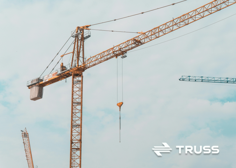 Construction cranes against a clear sky representing centralized treasury and multi-project cash management for contractors using Truss Payments.