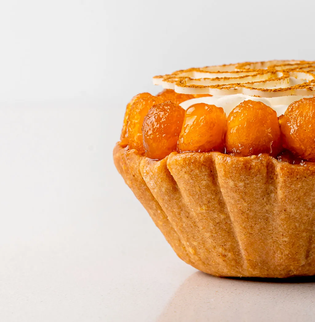 A pastry with a white frosting and a brown top.