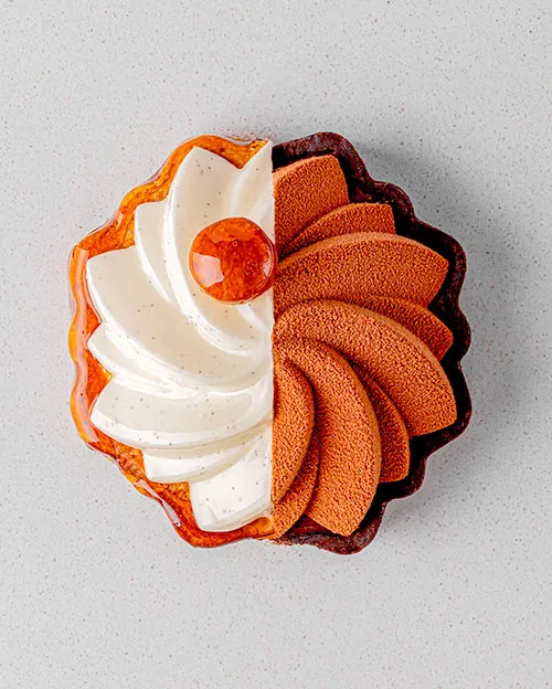 A slice of cake with white and brown frosting.