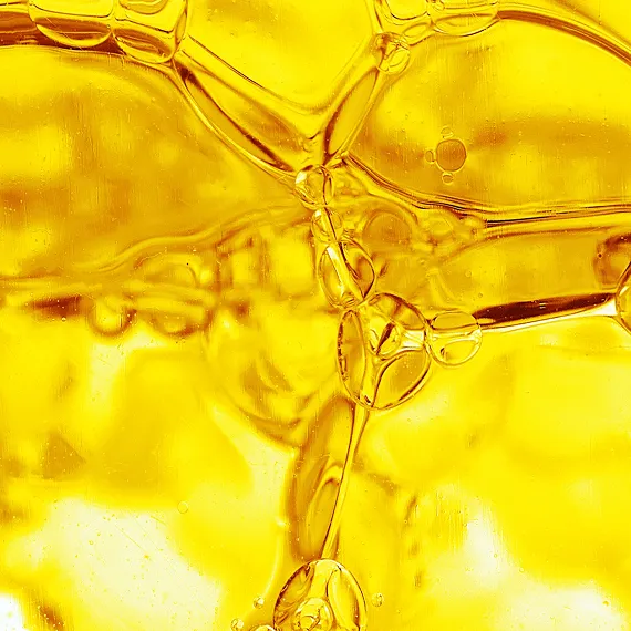 Close-up of golden yellow oil bubbles and fluid patterns.