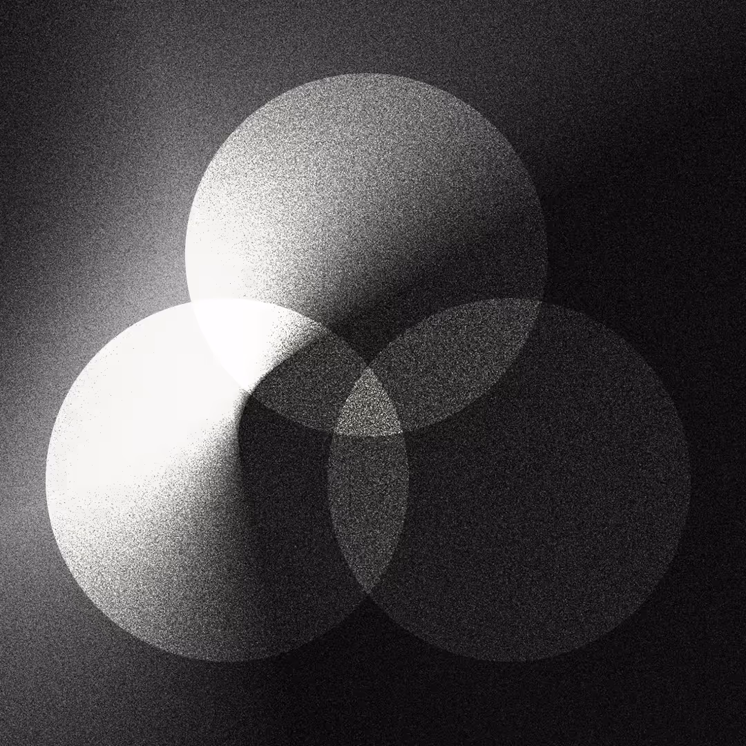 Trois cercles translucides en niveaux de gris se chevauchent sur un fond sombre, créant des zones d'ombre et de lumière graduées.