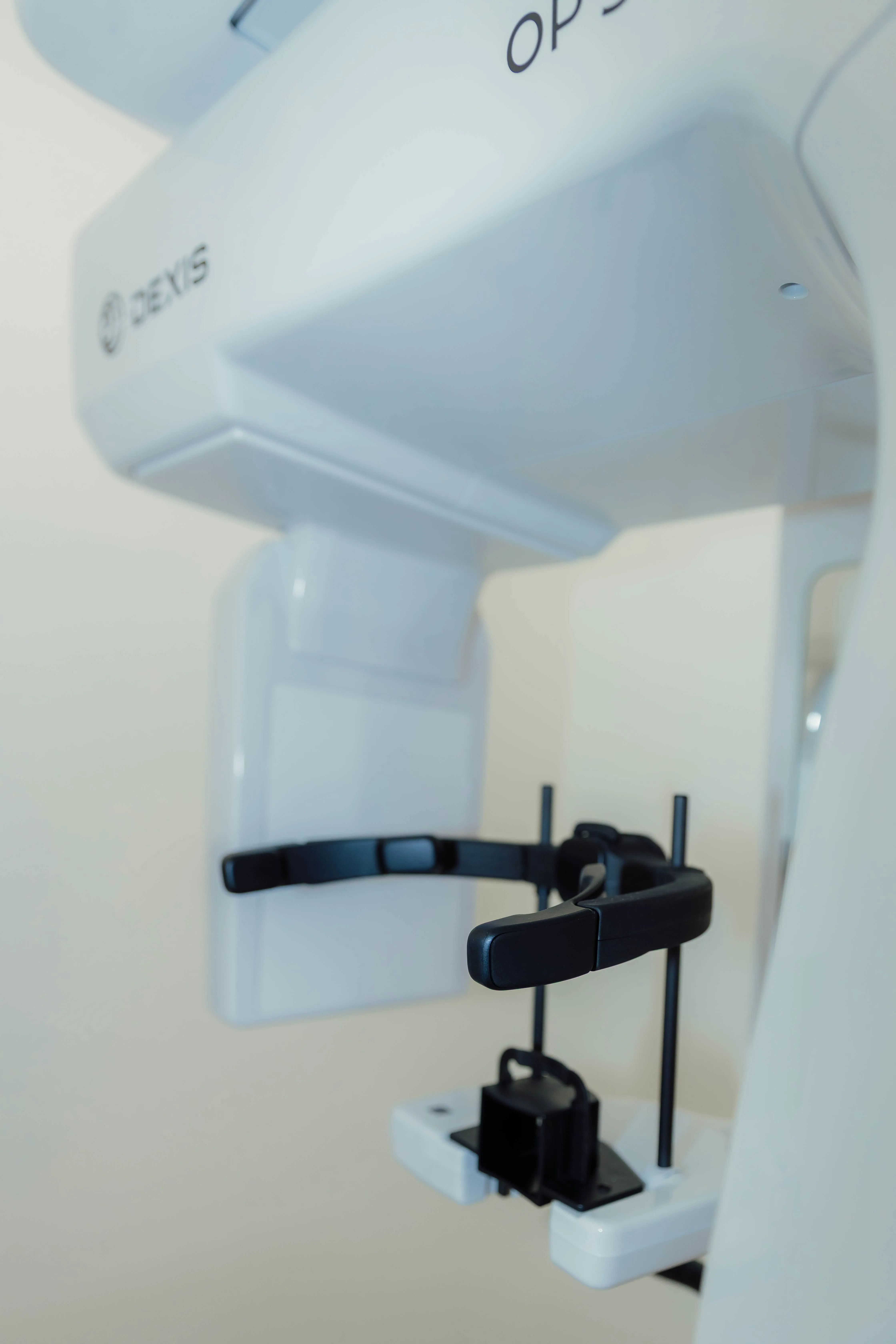 Close-up of a Dexis dental 3D imaging machine with a black adjustable head support.