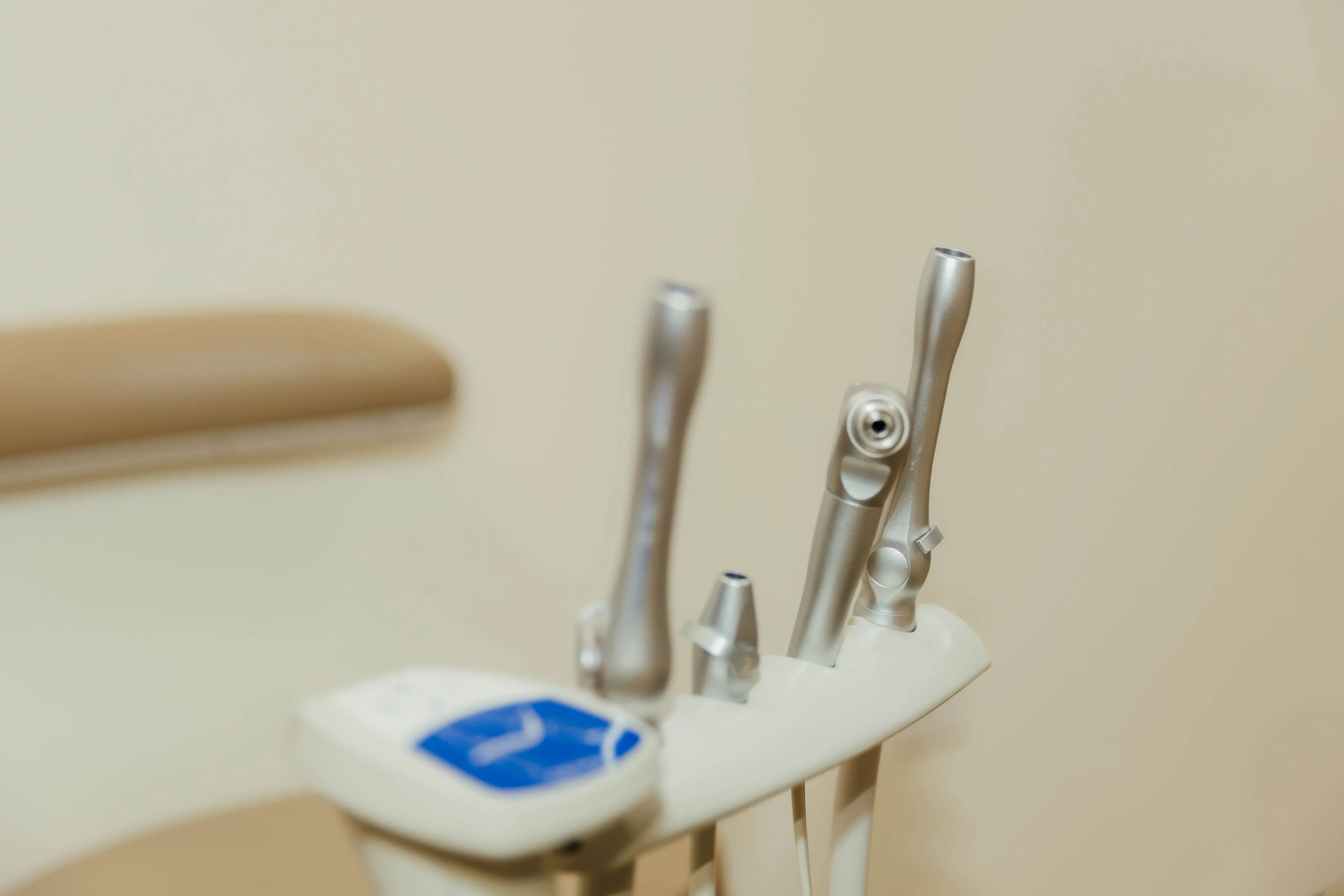 Close-up of dental handpieces and tools on a dental unit in a clinic.